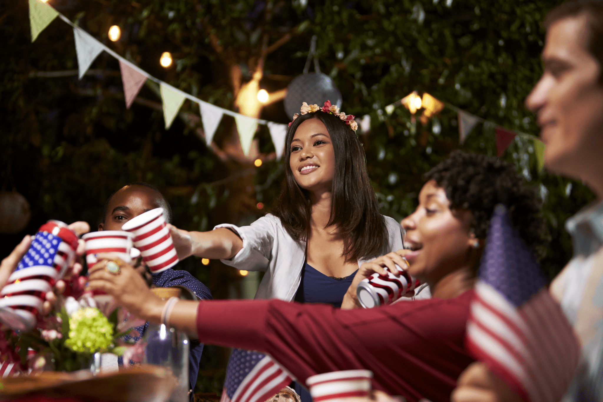Partygoers toasting with patriotic cups at a backyard celebration