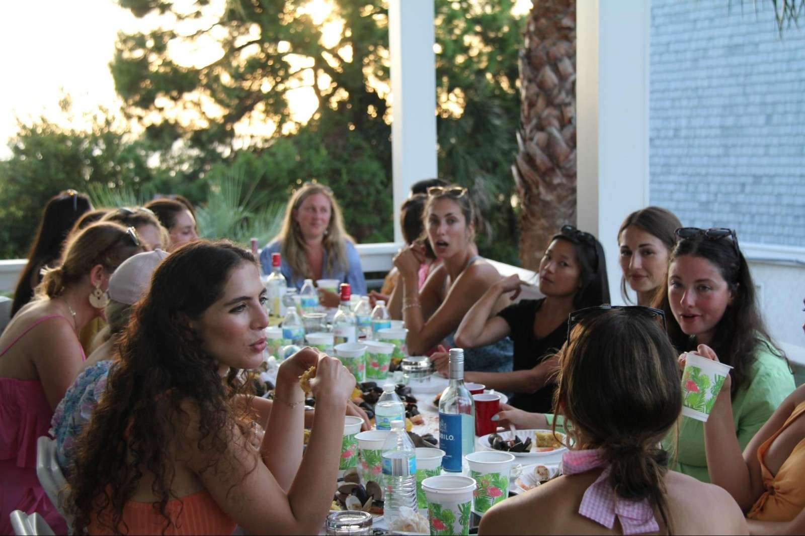 A joyful indoor dinner party with friends enjoying wine and food together.
