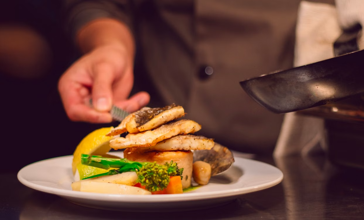 Gourmet fish dish with vegetables being served by a private chef in Charlotte.