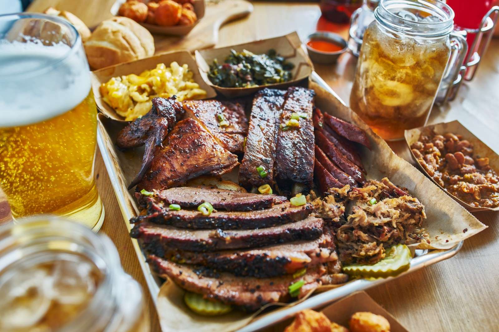 A tray of classic Texas barbecue alongside beer and sweet tea