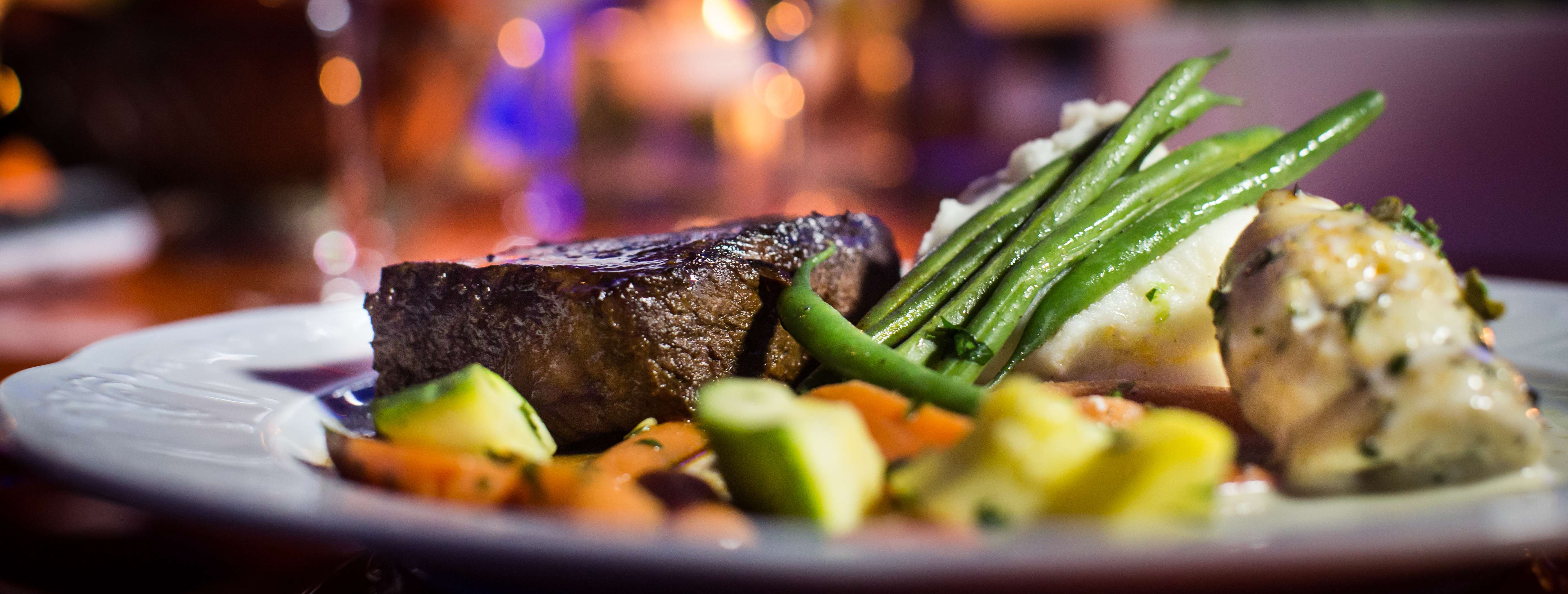 A beautifully plated steak with fresh vegetables