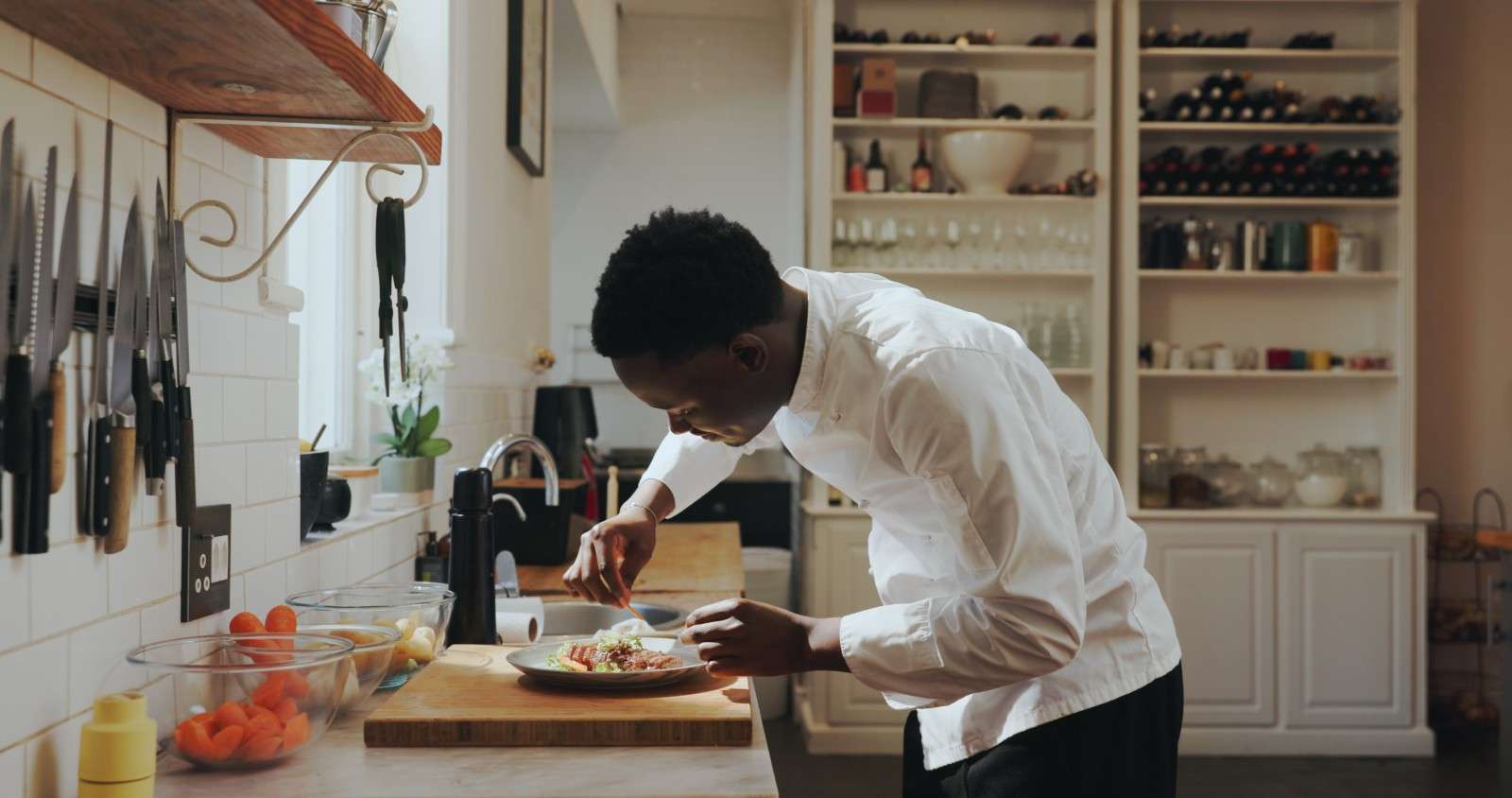 A private chef finishes a dish in a home kitchen